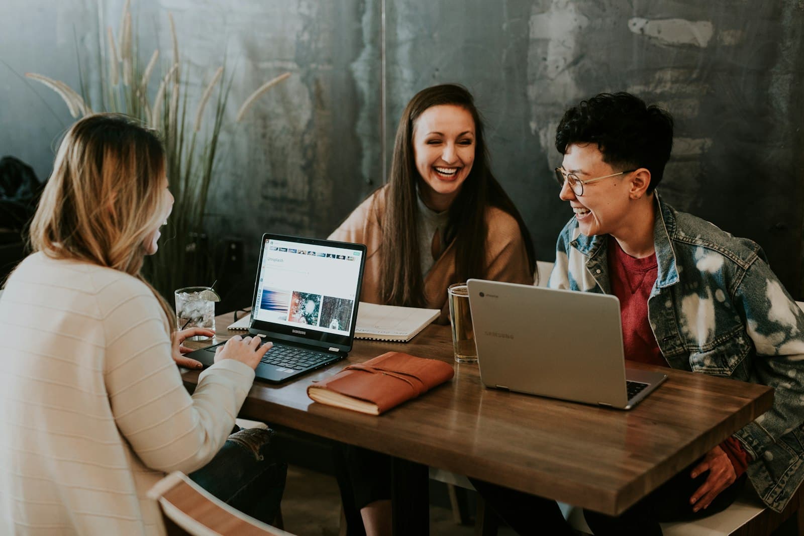 Laptops open around a shared work table